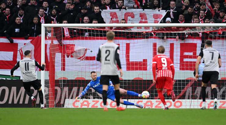 Vào! Mergim Berisha (Augsburg) giành chiến thắng trên chấm phạt đền bằng một cú sút chìm không thể cản phá, vượt qua tầm với của thủ môn Mark Flekken vào giữa khung thành.